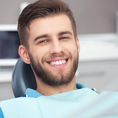 man smiling while in dentist chair