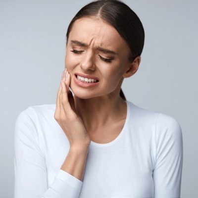 girl holding jaw in pain